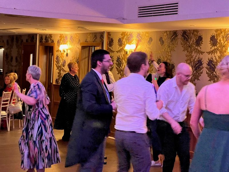 Wedding guests dancing in an elegant candlelit room