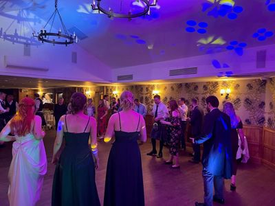 A ceilidh circle in full flow in a candlelit room