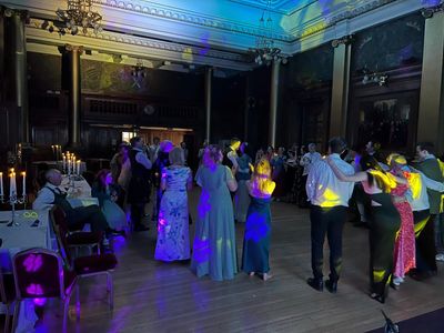 A grand ballroom ceilidh beneath glittering chandeliers