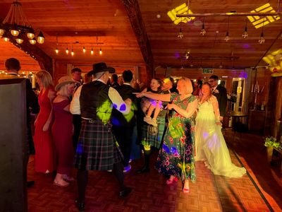 A huge circle dance fills a warm-lit barn