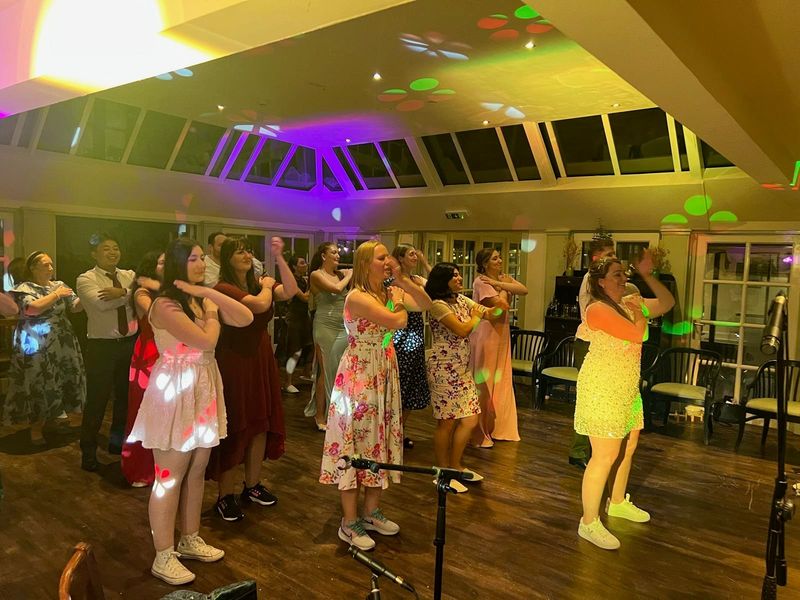 A bright daytime ceilidh with guests arm-in-arm on the floor