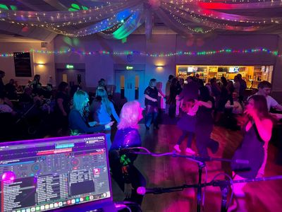 A vast ballroom full of dancers under a fairy-light ceiling