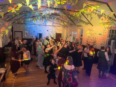 Dancers swing beneath a canopy of fairy lights