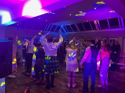 Guests in kilts throw their arms up during a lively set