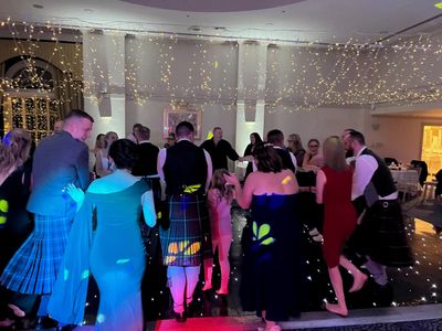 Couples dance close against twinkling fairy-light walls