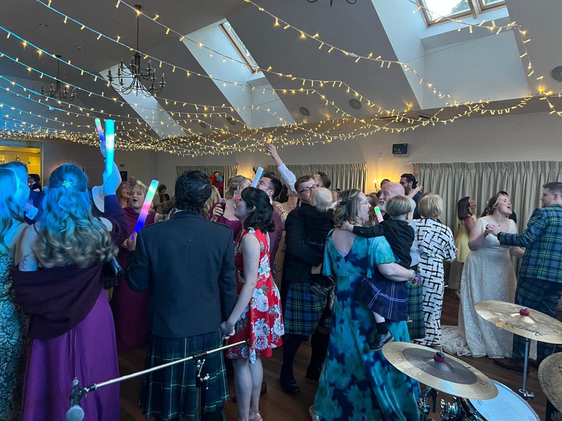 A wedding ceilidh in full swing under festoon lights